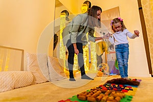 Therapist helping a young child living with cerebral palsy successfully improve her walking ability during therapy session. photo