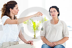 Therapist hypnotizing her patient photo
