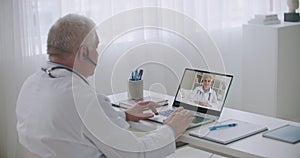 Therapist and infectious diseases specialist are consulting each other by video call from offices in clinics, experience