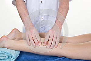 Therapist massaging human calf muscle.Therapist applying pressure on female leg.