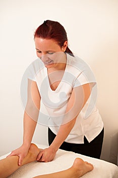 Therapist massaging a leg in a wellness center - spa