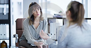 Therapist, psychologist or counsellor listening to a female patient during a session in her office. Mental health