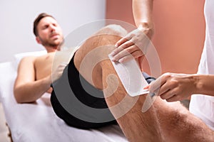 Therapist Removing Hair On Man`s Leg