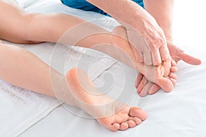 Therapist`s hands are doing a foot massage in the wellness center