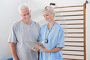 Therapist showing clipboard to senior man