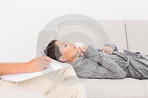 Therapist taking notes on her crying patient on the couch