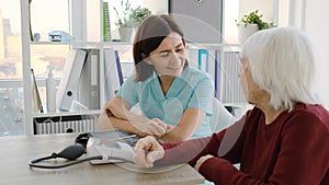 Therapist talking to old woman patient