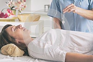 Therapist using pendulum to make a diagnosis