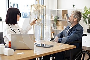 Therapist using skeleton to show injured site to patient