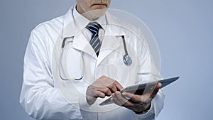 Therapist using tablet PC to check patients medical record or lab test results