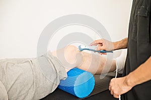 Therapist Using Ultrasound To Treat Patient`s Knee In Hospital