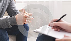 Therapist writing notes during counseling session with single man