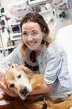 Therapy Dog Visiting Young Female Patient In Hospital