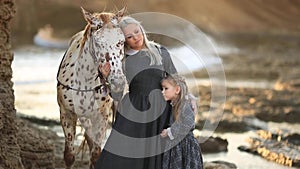 Therapy with horses. Woman with a daughter taking care of her horse. slow motion full hd