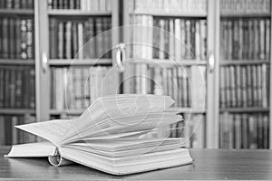 There is a book in the background of a bookcase.