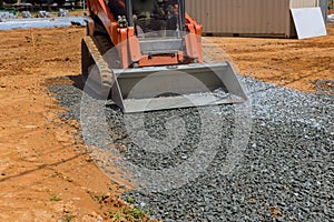 There is a bucket full of crushed stone being loaded into an excavator as it hauls a full bucket of gravel into