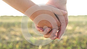 There is close-up hand in hand of man and woman on sunset background