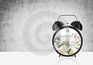 There is EURO bills inside the alarm clock which is on the table. The concept of 'time is money' and a time management.
