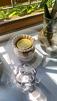 there is a glass bowl with lemon slices on top of coffee grounds, with a coffee filter