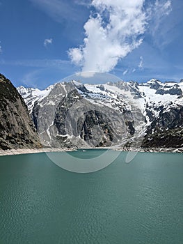 there is a large body of water with snow covered mountains behind it