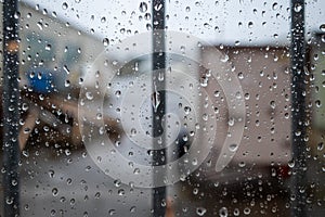 large raindrops on a barred window pane