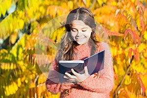 There is no end to education. Small child read book on autumn day. Small child enjoy reading on autumn landscape. Even photo
