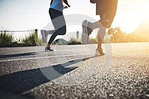 There is no finish line. two unrecognizable people running on a tarmac road.