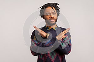 There is no way. Concerned disappointed african man with dreadlocks showing x sign with crossed hands, meaning stop, finish
