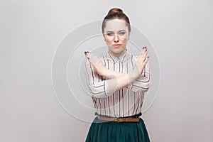 There is no way. Portrait of serious beautiful young woman in striped shirt and green skirt and collected ban hairstyle, standing