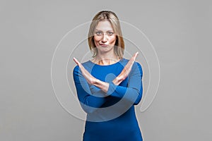 There is no way. Portrait of woman crossing hands, showing block, X sign, this is the end. indoor studio shot isolated on gray