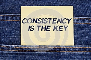 There is a paper sticking out of a jeans pocket with the inscription - Consistency Is The Key
