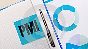 There is a pen between the blue sticky note with the text PMI Project Management Institute and the blue chart. Business concept.
