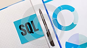 There is a pen between the blue sticky note with the text SQL Structured Query Language and the blue chart. Business concept. View