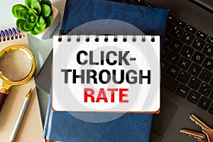 There is a piece of paper with the word Click Through Rate on notebook with red cube