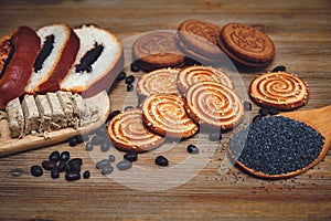 There are Pieces of Roll with poppyseed,Cookies,Halavah,Chocolate Peas,Tasty Sweet Food on the Wooden Background,Toned