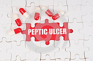 There are pills on the white puzzles, in the middle there is a red surface with the inscription - Peptic ulcer