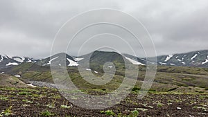 There is scant green vegetation in the valley.