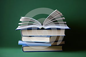 There is a stack of books, and on the top, there is an open book