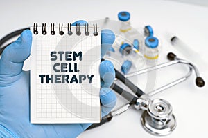 There is a stethoscope on the table, the doctor holds a notebook in his hand with the inscription - STEM CELL THERAPY