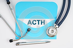 There is a stethoscope on the table, an envelope with paper on which it is written - ACTH