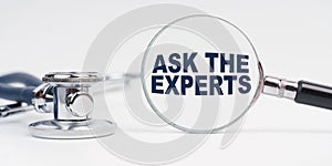 There is a stethoscope on the table, a magnifying glass with the inscription - ASK THE EXPERTS