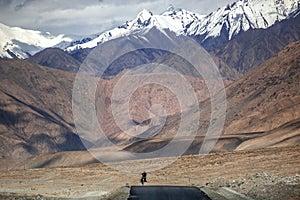 There is a tarmac road under the magnificent, beautiful and charming snowy mountains photo
