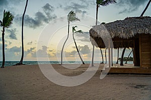 there is a thatch hut on the beach next to the water