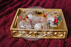 There is a tray with Christmas tree toys on the bard knitted bedspread