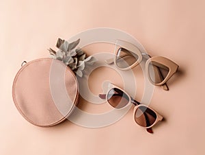 There are two pairs of sunglasses placed on pink background. One pair is positioned near center of frame, while other pair is