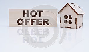 There is a wooden house and a sign on the table - Hot Offer