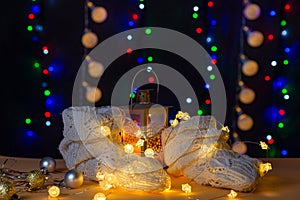 There are wool white socks like foots, lights and candle stick behind the socks on the table/background.