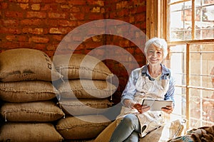 Theres always great recipes online. Cropped portrait of a senior woman using a tablet while working in a roastery.