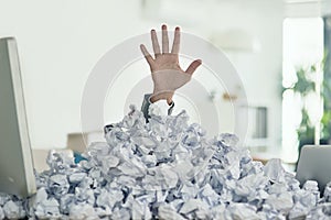 Theres a light at the end of the admin tunnel. Shot of an unidentifiable businessman drowning under a pile of paperwork