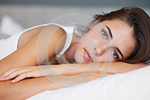 Theres a lot on my mind today...A beautiful young woman looking sad while lying on her bed.